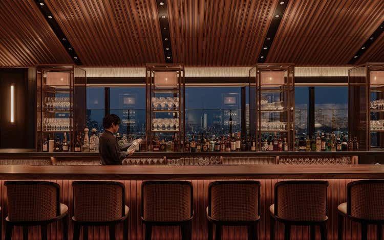 Sophisticated bar with panoramic urban backdrop.