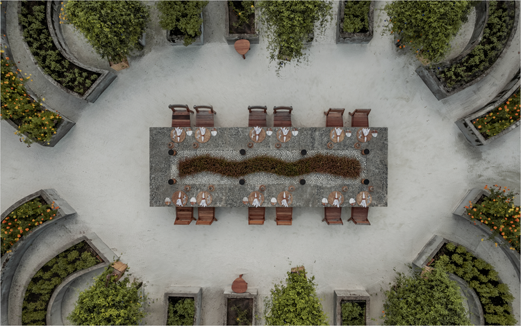 Long dining table in tropical courtyard.
